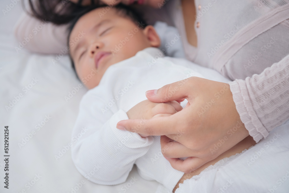 Loving mom carying of her newborn baby at home. Bright portrait of happy mum holding sleeping infant child on hands. Mother hugging her little 6 months old son. Family in the house. Lifestyle. Loving mom carying of her newborn baby at home. Bright portrait of happy mum holding sleeping infant child on hands. Mother hugging her little 6 months old son. Family in the house. Lifestyle.