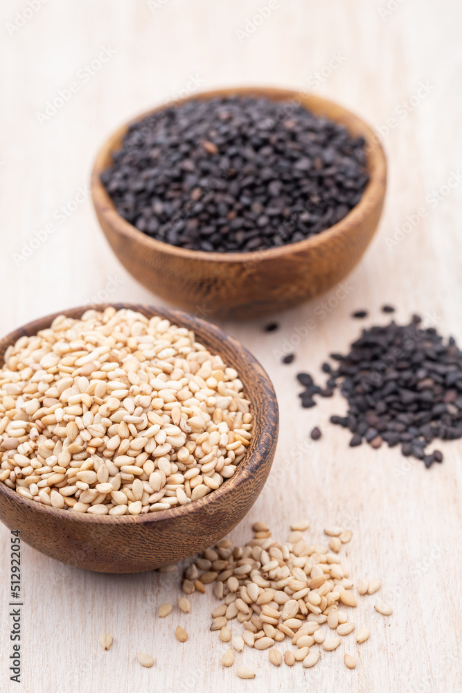 White sesame and black sesame seed on wooden bowl. White sesame and black sesame seed on wooden bowl.
