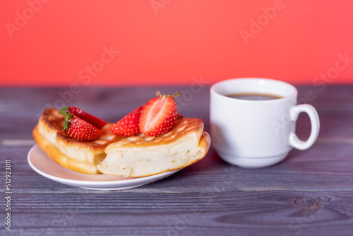 Belgian waffles with strawberries and coffee on a wooden  dark table.