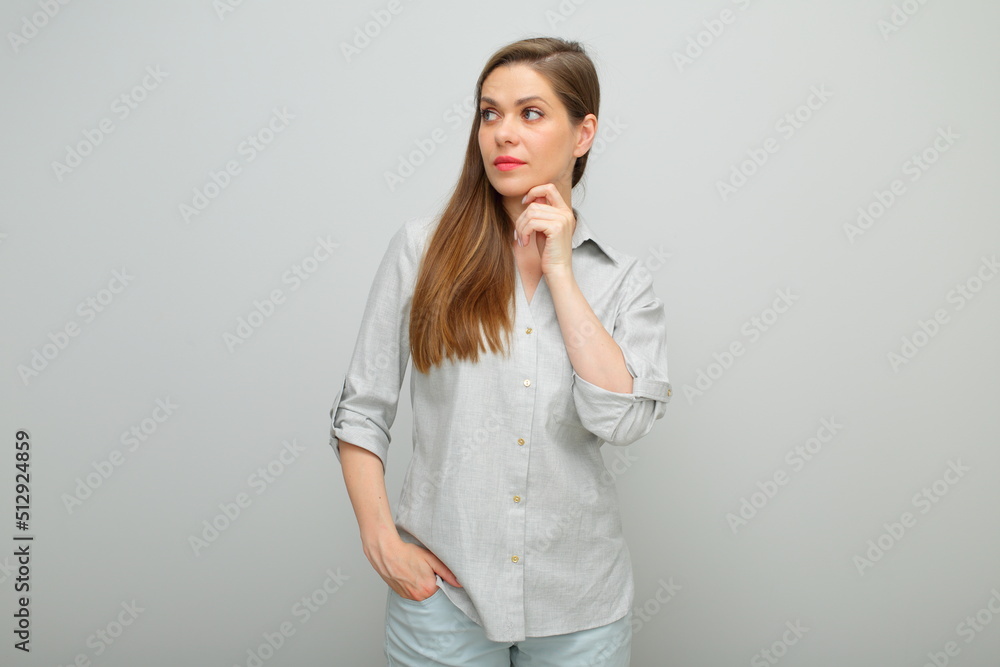 Thinking serious woman touching her face and looking away, isolated female portrait, young lady dressed pants and gray shirt. Thinking serious woman touching her face and looking away, isolated female portrait, young lady dressed pants and gray shirt.