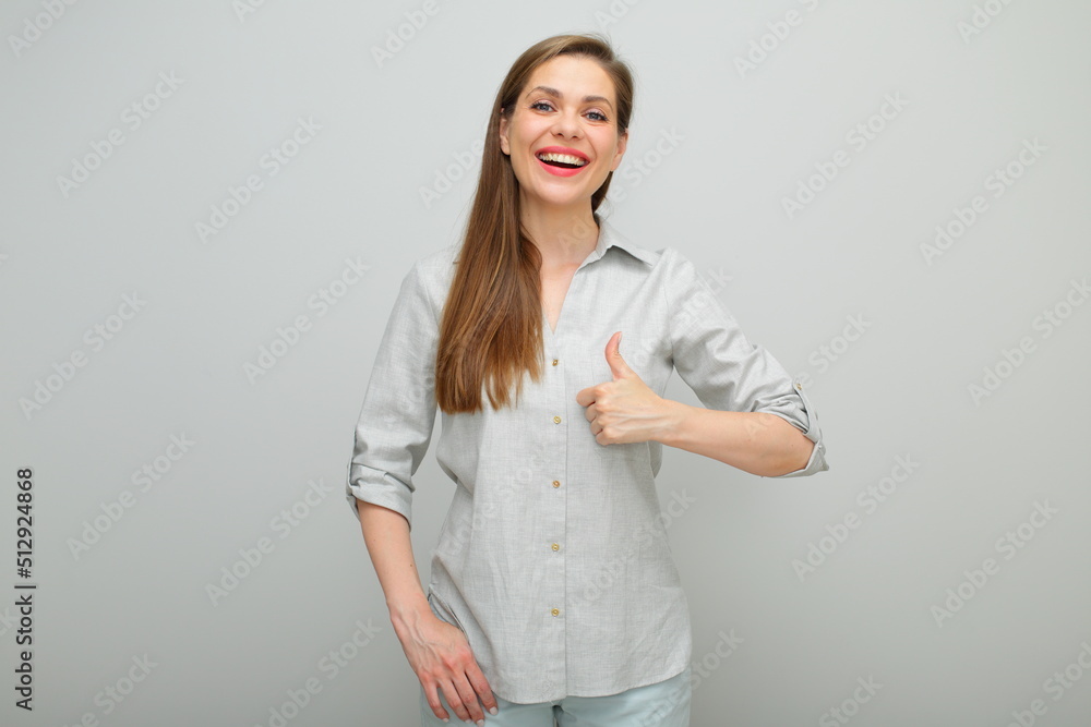 Thumb up. Happy woman, isolated female portrait, young lady dressed pants and gray shirt. Thumb up. Happy woman, isolated female portrait, young lady dressed pants and gray shirt.