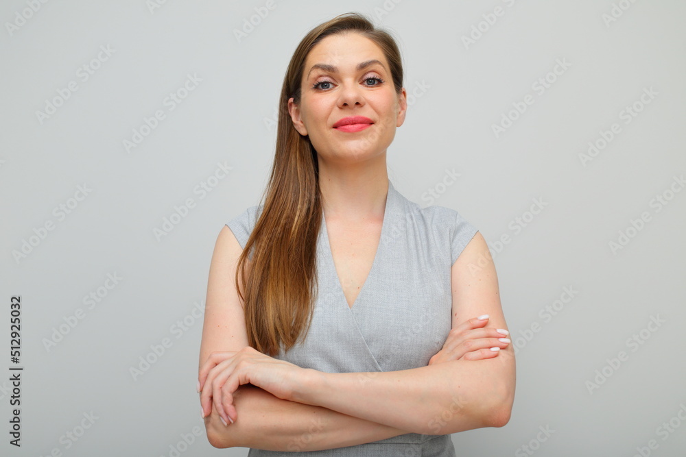 Obraz premium Smiling woman in business dress standing with arms crossed, female portrait with long hair isolated on gray.