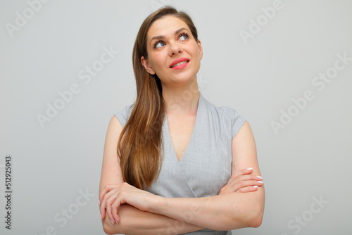 Smiling smiling woman touching her face and looking away, gray business dress isolated portrait.