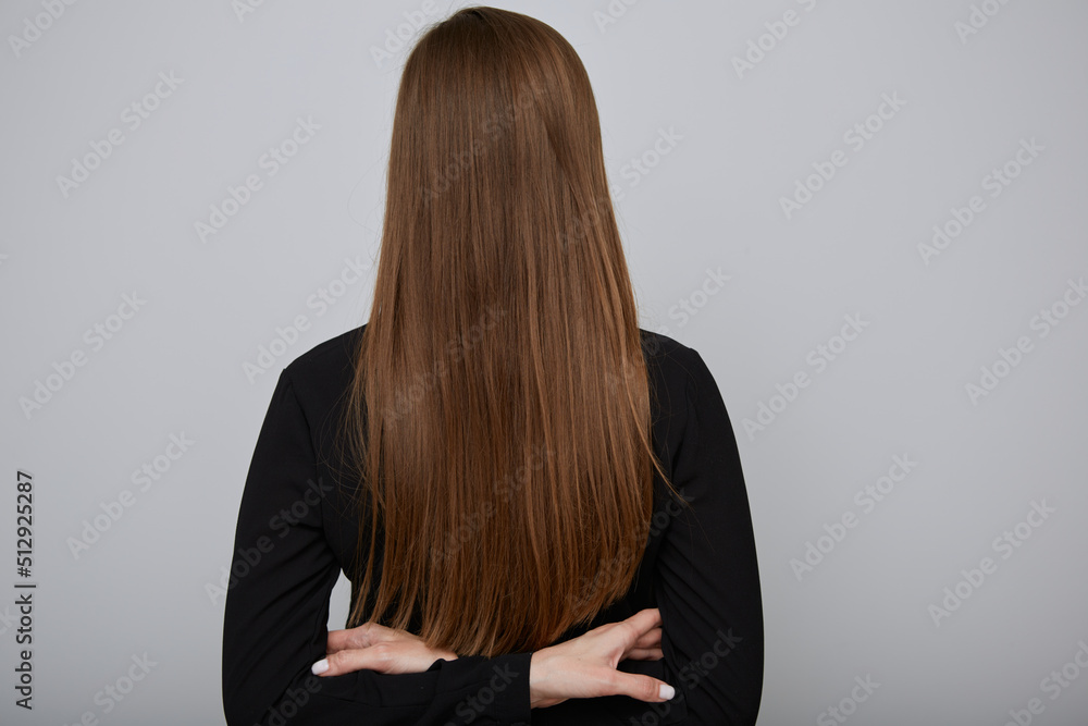 Naklejka premium Back woman with long hair and crossed arms. Girl in black shirt isolated portrait.