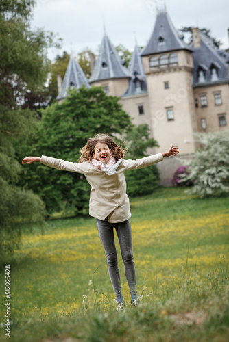 Girl jumps on the background of the castle in Goluchow, Poland.