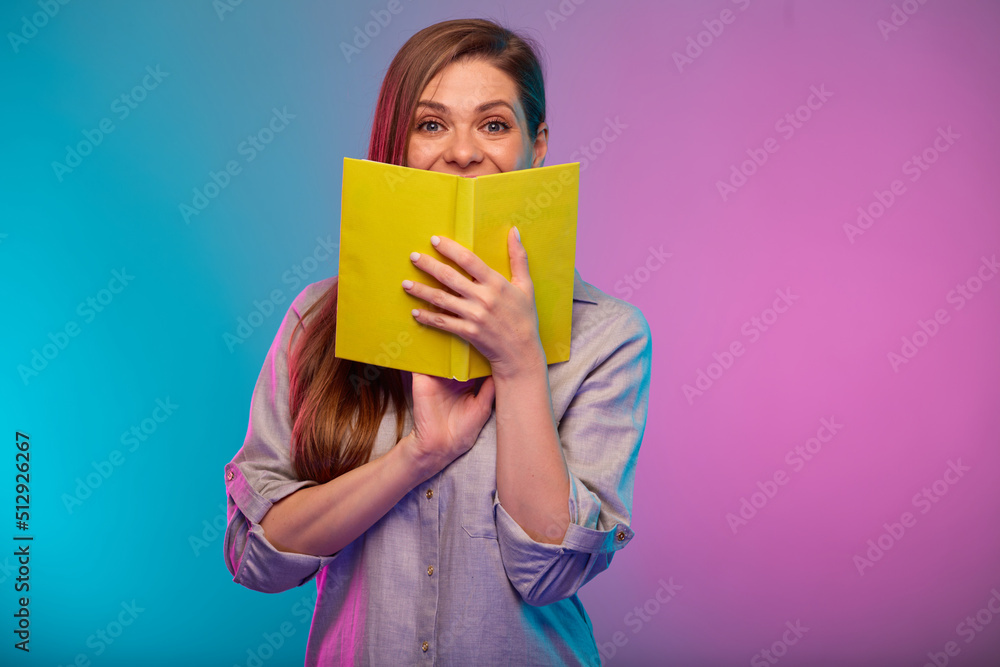 Teacher or student woman covered her face with open book, portrait with neon lights colors effect. Female model isolated on neon background Teacher or student woman covered her face with open book, portrait with neon lights colors effect. Female model isolated on neon background