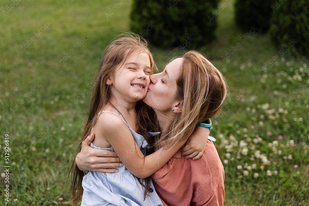 Daughter kissing and hug her mom. Hapiness emotion. Family values. Happy family lifestyle. Happiness and joy of mom hugging her child. Daughter kissing and hug her mom. Hapiness emotion. Family values. Happy family lifestyle. Happiness and joy of mom hugging her child.