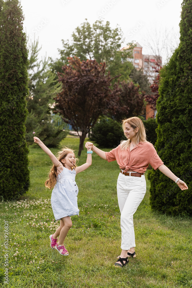 Obraz premium Mom and daughter having fun together. Happy family lifestyle. Daughter jumping, smiling and laughing. Love in family.