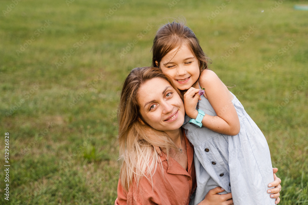Mom and daughter embrace and smile. Family values. Happy family lifestyle. Happiness and joy of mom hugging her child. Mom and daughter embrace and smile. Family values. Happy family lifestyle. Happiness and joy of mom hugging her child.