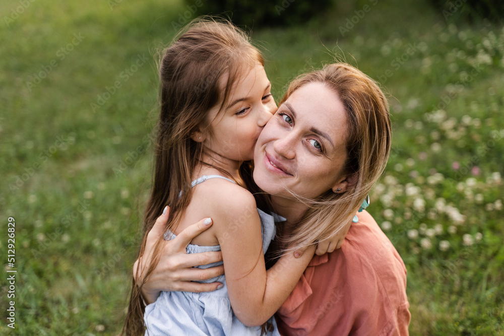 Daughter kissing and embrace her mom. Hapiness emotion. Family values. Happy family lifestyle. Happiness and joy of mom hugging her child. Daughter kissing and embrace her mom. Hapiness emotion. Family values. Happy family lifestyle. Happiness and joy of mom hugging her child.