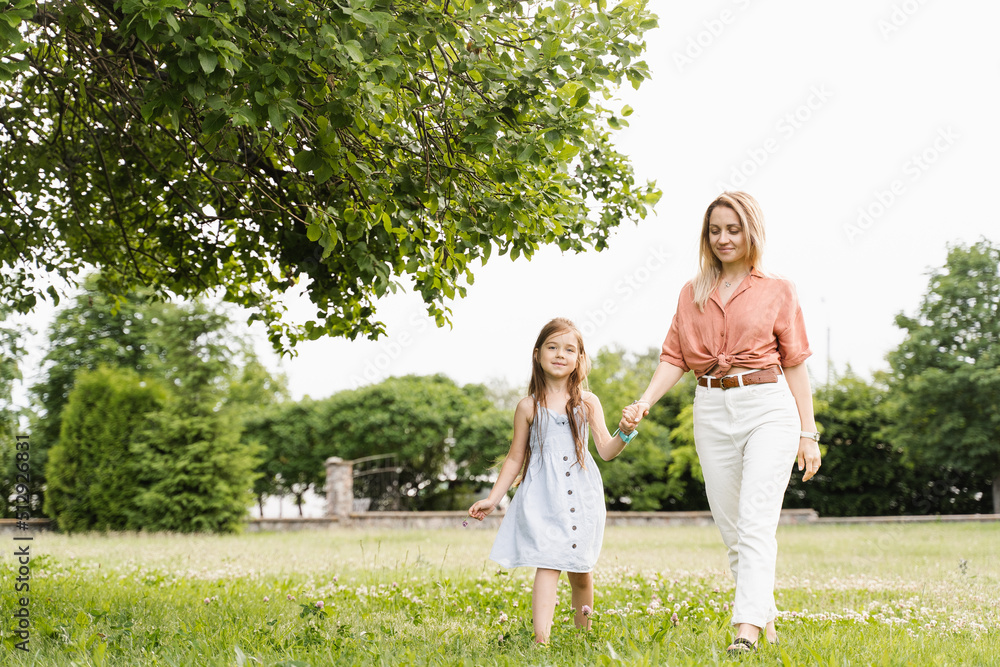 Mom and daughter walking and having fun together in the park. Happy family lifestyle. Love in family. Hapiness of mother and her child.