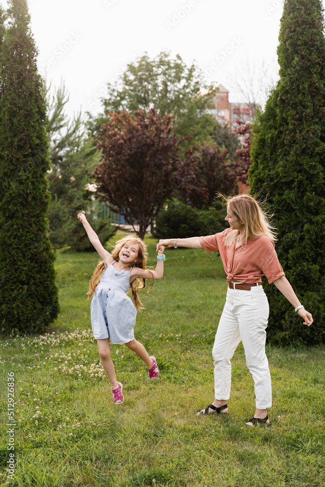 Obraz premium Mom and daughter having fun together. Happy family lifestyle. Daughter jumping, smiling and laughing. Love in family.
