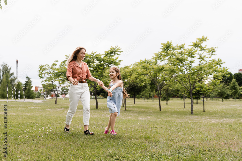 Mom and daughter run in the park and have fun. Family values and traditions. Happy childhood of a child. Mother plays with her daughter. Mom and daughter run in the park and have fun. Family values and traditions. Happy childhood of a child. Mother plays with her daughter.