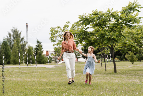 Mom and daughter run in the park and have fun. Family values and traditions. Happy childhood of a child. Mother plays with her daughter.