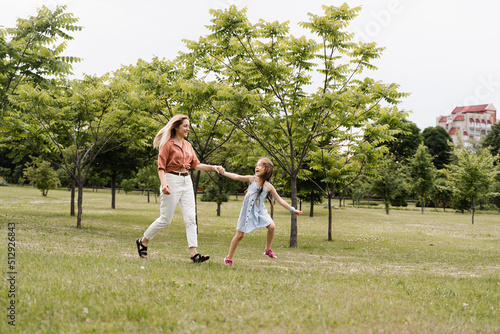 Mom and daughter run in the park and have fun. Family values and traditions. Happy childhood of a child. Mother plays with her daughter.