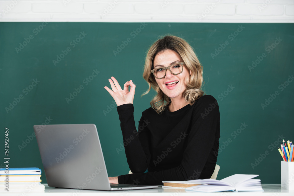 Portrait of funny amazed teacher teaching line of high school students with computer laptop in classroom on blackboard. Portrait of funny amazed teacher teaching line of high school students with computer laptop in classroom on blackboard.