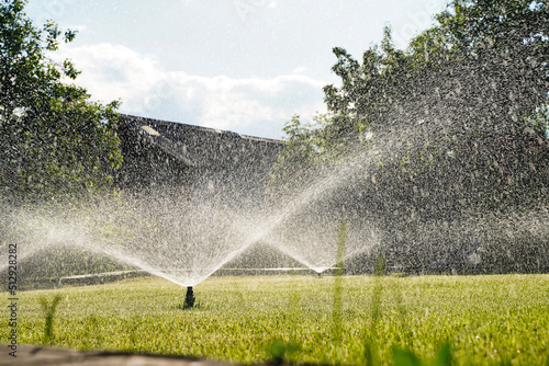 Backyard Watering Technology for green lawn. Automatic Garden Sprinkler.  photo