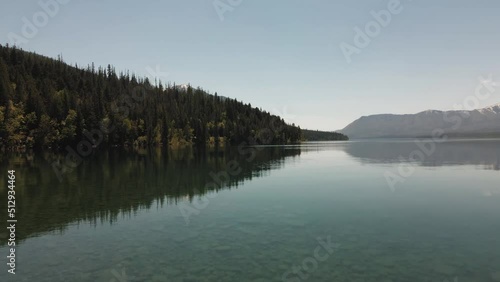cinematic Lake Mcdonald flying low on top of the lake, national forest and mountains photo