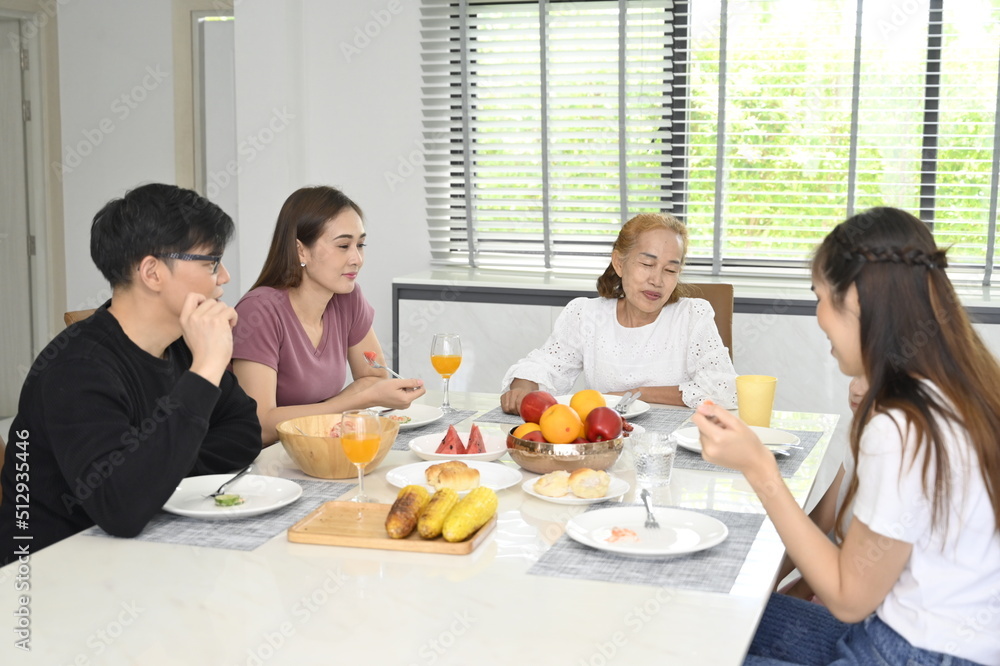 Cute little girl having lunch with  family at home.