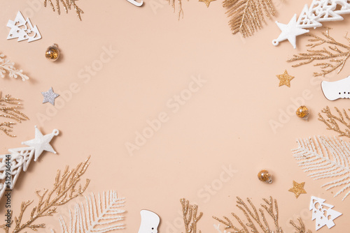 Christmas greeting card tempalte of golden glitter twigs and Christmas decorations on pastel beige. Empty copy space for greeting text