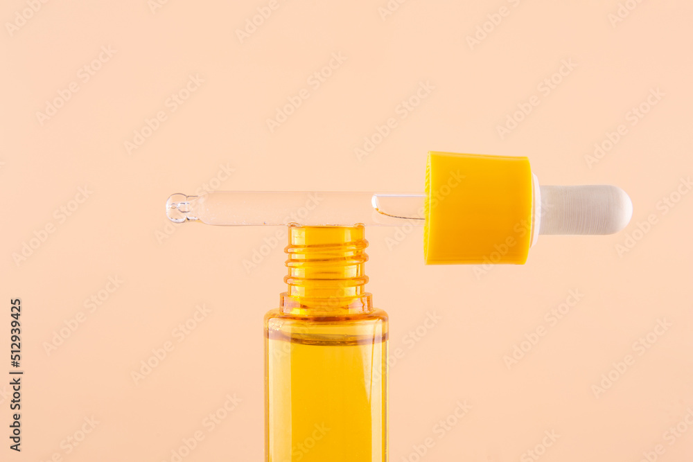 glass yellow bottle with pipette with essential oil on beige background top view. Aromatic cosmetic product for skin hair care Moisturizing beauty product with vitamin C close up glass yellow bottle with pipette with essential oil on beige background top view. Aromatic cosmetic product for skin hair care Moisturizing beauty product with vitamin C close up