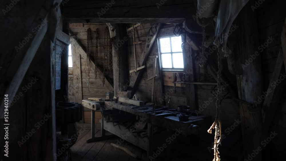 Wood workshop in a old dark wooden windmill lit by natural light from window Wood workshop in a old dark wooden windmill lit by natural light from window