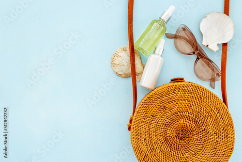 Flatlay of rattan bag withbeach accessories and seashells. Summer beach background photo