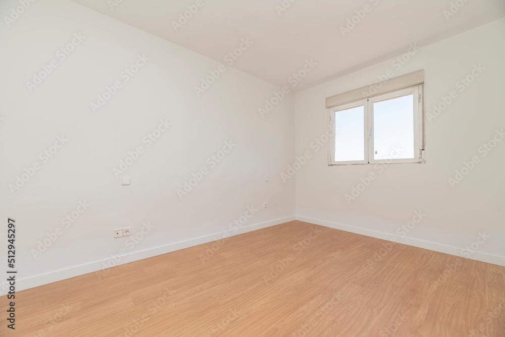 Empty room with light oak flooring, white carpentry on the baseboards and aluminum window with views Empty room with light oak flooring, white carpentry on the baseboards and aluminum window with views