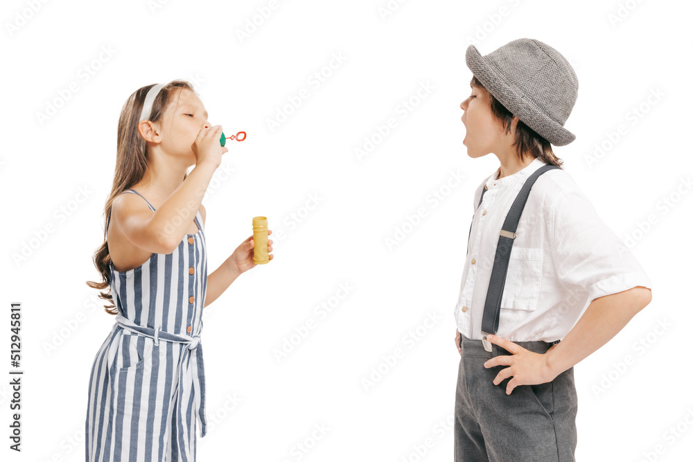 Portrait of two cheerful kids in retro style summer outfit isolated on white background. Concept of art, friendship, hope, youth, fashion Portrait of two cheerful kids in retro style summer outfit isolated on white background. Concept of art, friendship, hope, youth, fashion