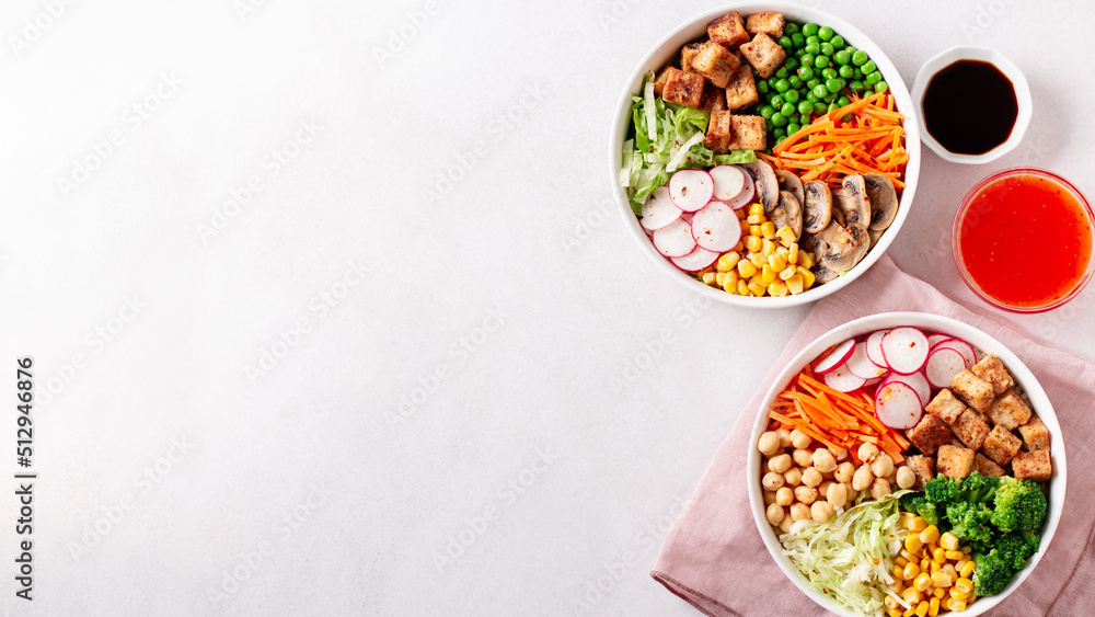 Vegan buddha bowl with tofu, colorful vegetables on base of brown rice.
