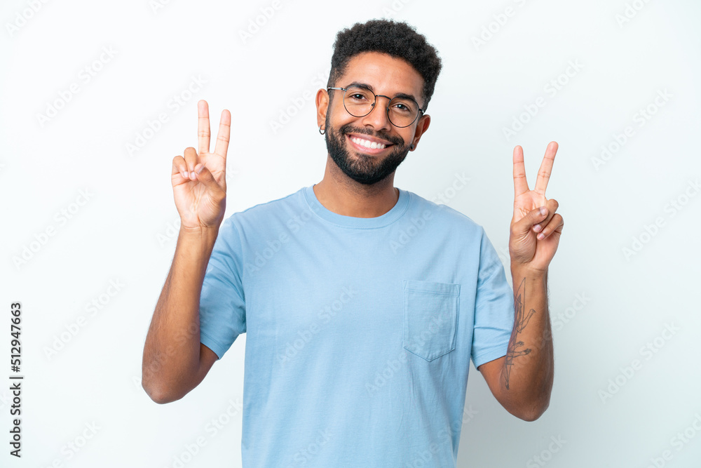 Young Brazilian man isolated on white background showing victory sign with both hands Young Brazilian man isolated on white background showing victory sign with both hands