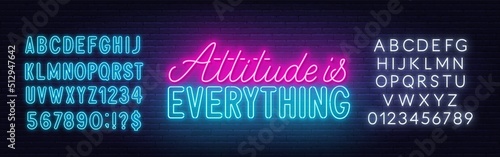 Attitude is everything neon quote on a brick wall.