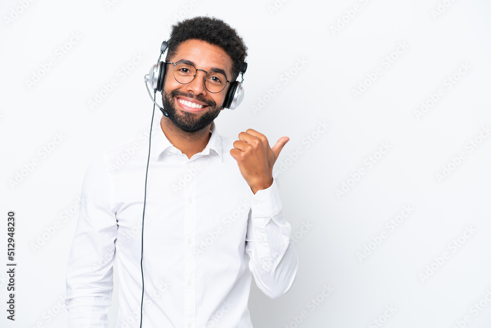 Telemarketer Brazilian man working with a headset isolated on white background pointing to the side to present a product Telemarketer Brazilian man working with a headset isolated on white background pointing to the side to present a product