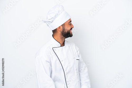 Young Brazilian chef man isolated on white background laughing in lateral position