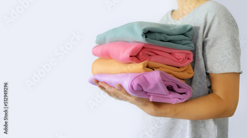 Women's hand give a stack of clothes to children's hands. Helping the poor, helping those in need. Clothes Donation, Renewable Concept. Preparing Garment at Home before Donate. Help from volunteers