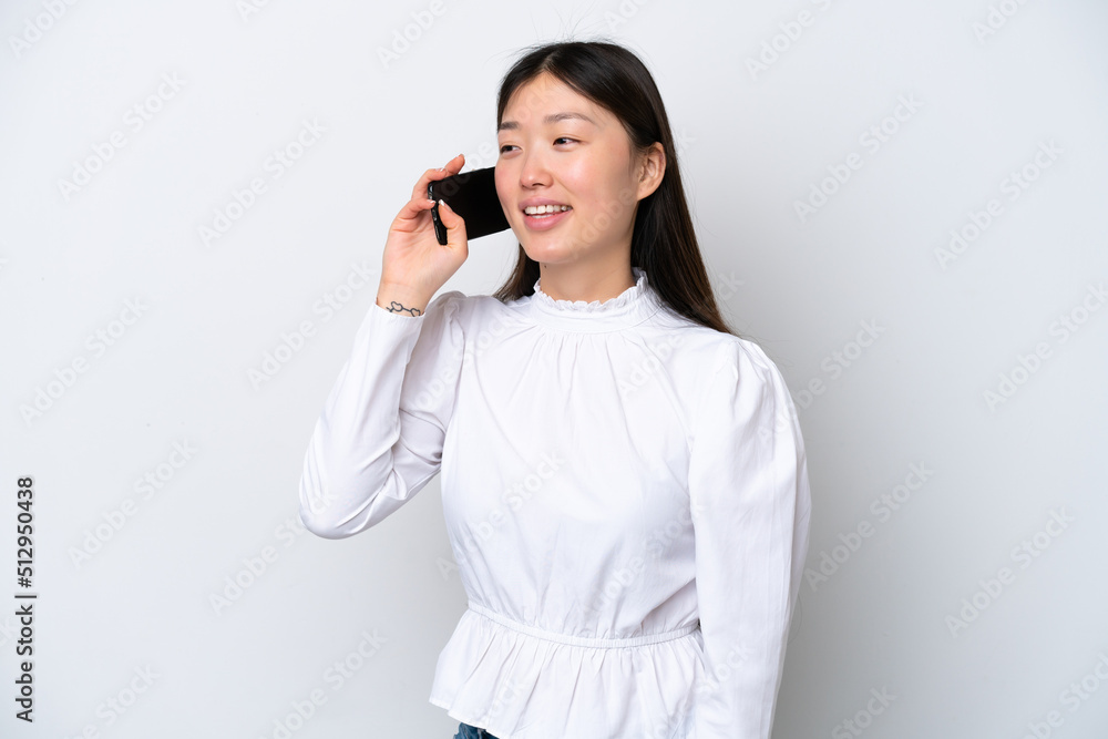 Young Chinese woman isolated on white background keeping a conversation with the mobile phone Young Chinese woman isolated on white background keeping a conversation with the mobile phone