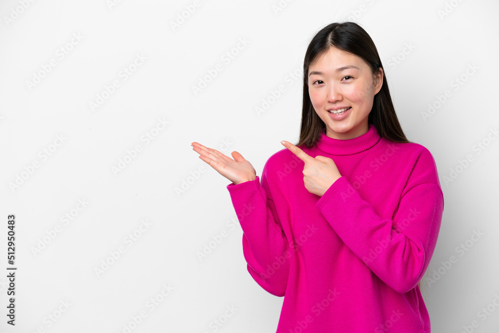Young Chinese woman isolated on white background holding copyspace imaginary on the palm to insert an ad Young Chinese woman isolated on white background holding copyspace imaginary on the palm to insert an ad