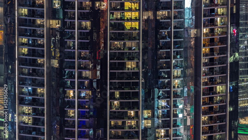 Windows in apartments of a high class building at night timelapse