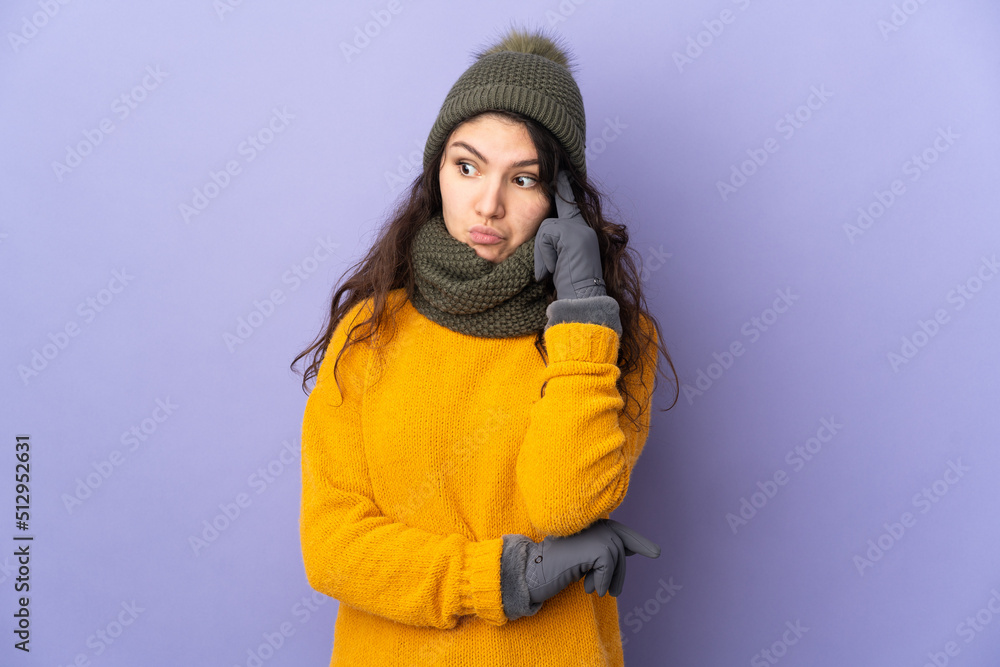 Teenager Russian girl with winter hat isolated on purple background thinking an idea Teenager Russian girl with winter hat isolated on purple background thinking an idea