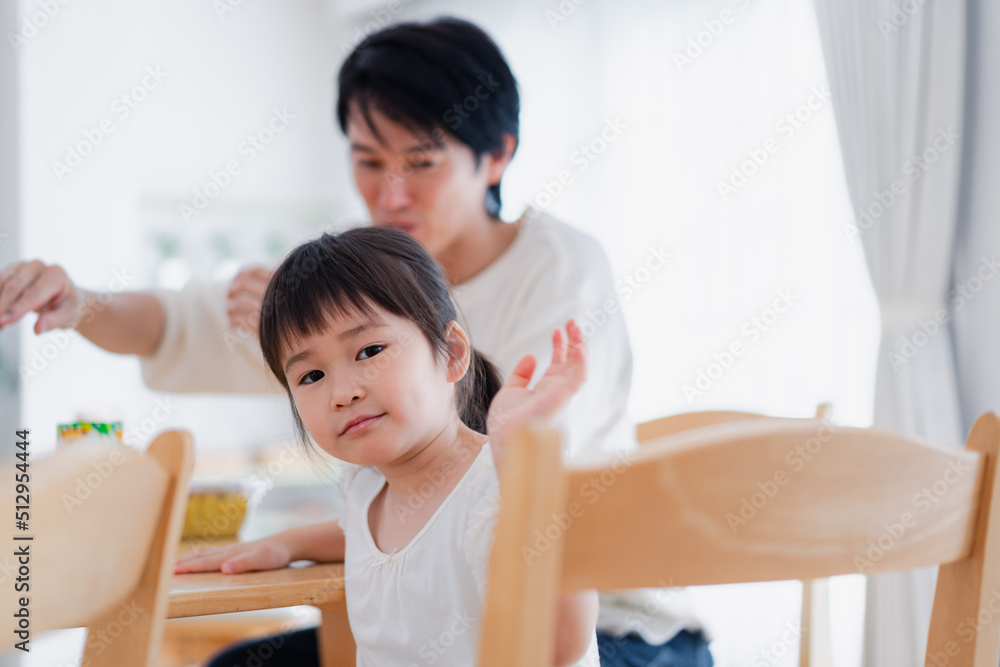 Fototapeta premium パパと一緒にご飯を食べる小さな女の子