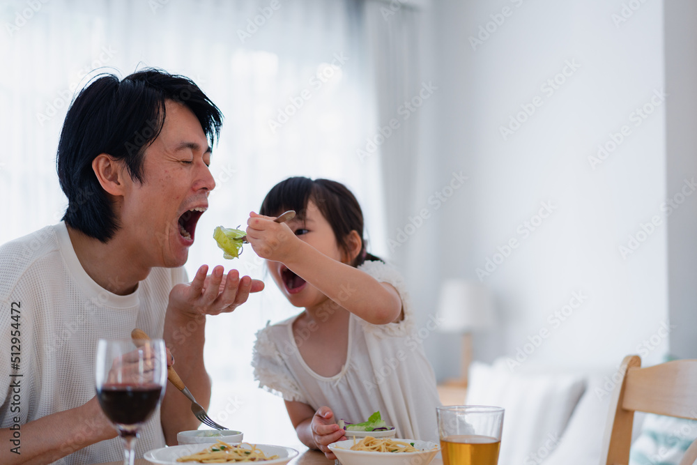 パパと一緒にご飯を食べる小さな女の子 パパと一緒にご飯を食べる小さな女の子