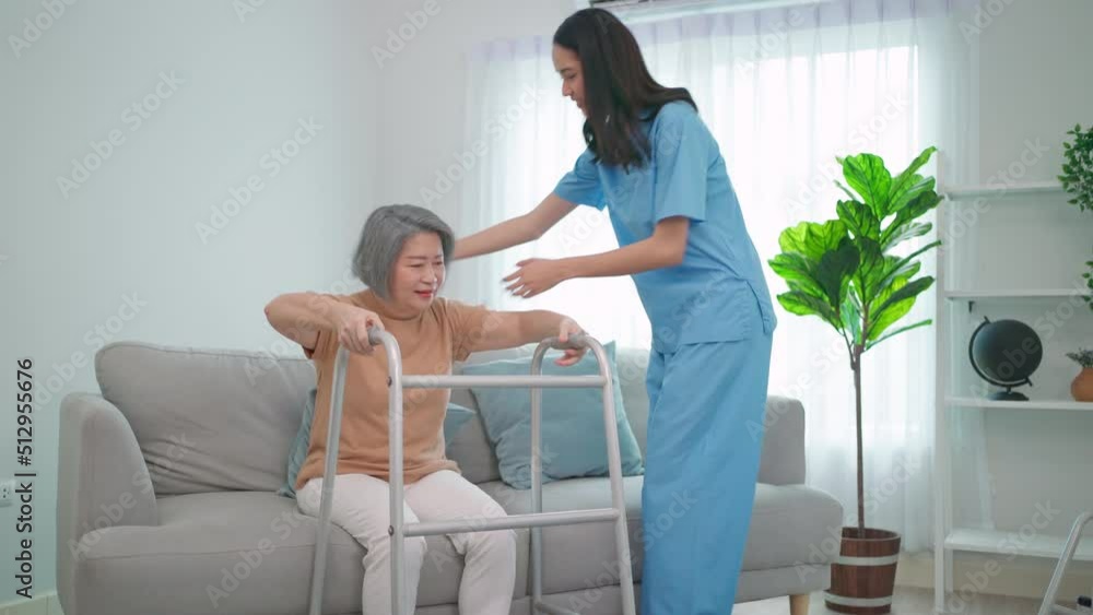 Young caregiver doctor take care elderly people stand up and walking by using walking aid. Pretty nurse support senior older or patient doing physical therapy at home. Healthcare and therapy. Young caregiver doctor take care elderly people stand up and walking by using walking aid. Pretty nurse support senior older or patient doing physical therapy at home. Healthcare and therapy.
