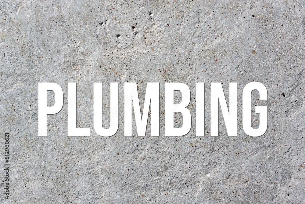 PLUMBING - word on concrete background. Cement floor, wall. PLUMBING - word on concrete background. Cement floor, wall.
