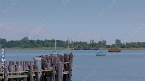 Roll-on, roll-off orange ferry heading to Hart Island, boats and dock in the foreground. Blue sky on a sunny day. photo