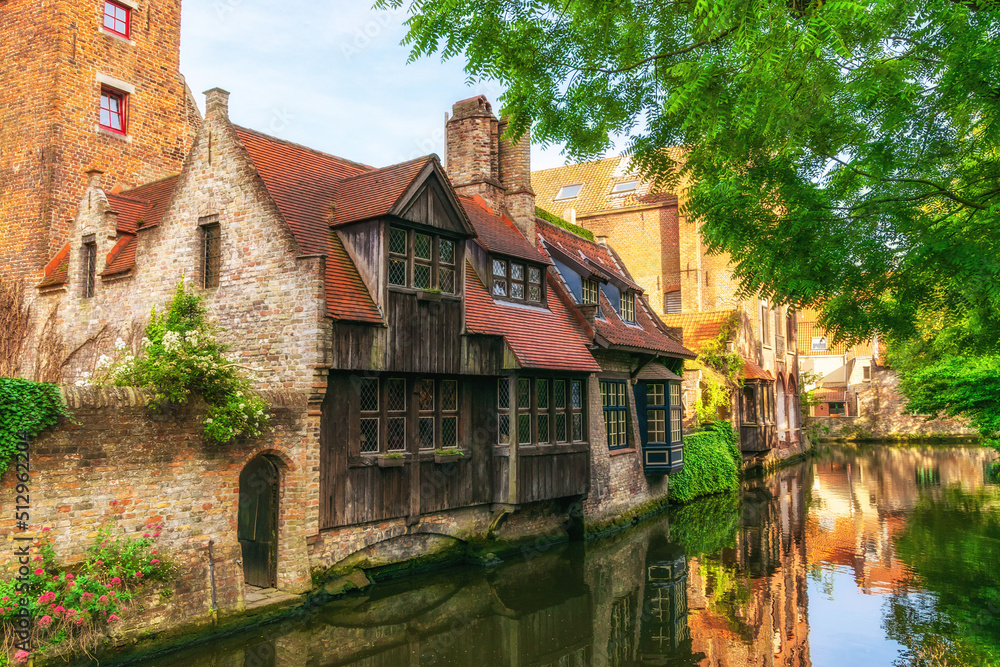 Obraz premium Bruges, Belgium - Cityscape overlooking old quiet streets with old brick houses and a canal on a summer sunny day.
