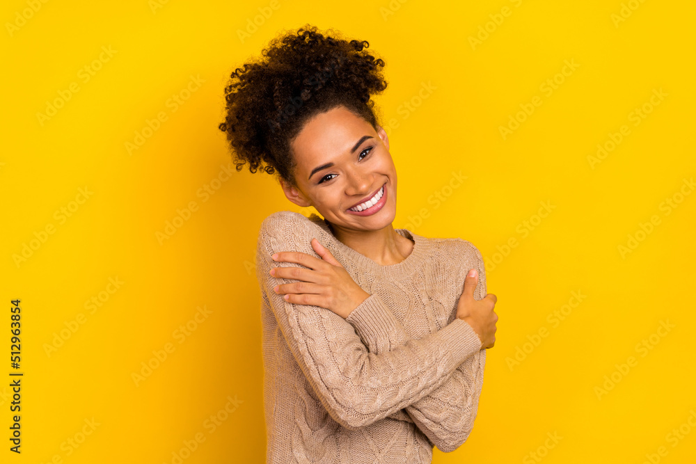 Photo of dreamy adorable woman wear beige sweater hugging herself isolated yellow color background Photo of dreamy adorable woman wear beige sweater hugging herself isolated yellow color background