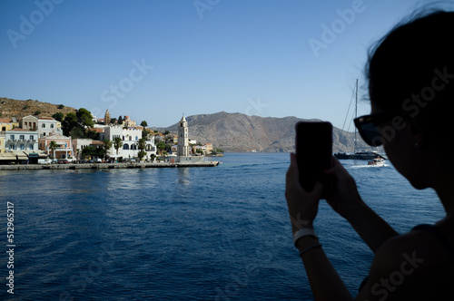 Woman phone  Symi greek island coast mediterranean village 