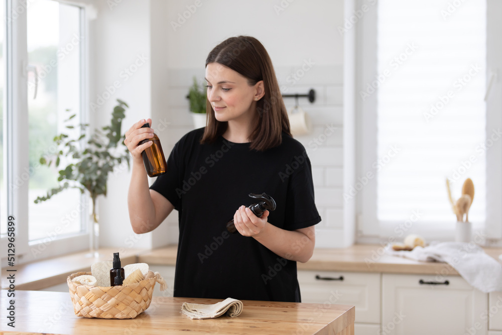 Young woman cleans the kitchen with eco products. Young woman cleans the kitchen with eco products.