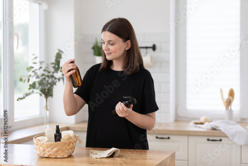 Young woman cleans the kitchen with eco products.