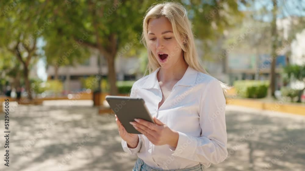 Young blonde woman smiling confident using touchpad at park Young blonde woman smiling confident using touchpad at park